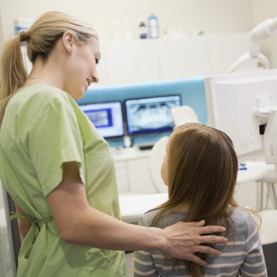 Tips for overcoming dental anxiety 2 Female dental assistant comforting a young girl dealing with dental anxiety